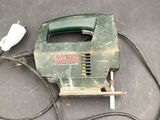 a green electric hand held stapler on a table