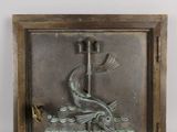 bronze plaque of a fish on a boat with a bird in the water