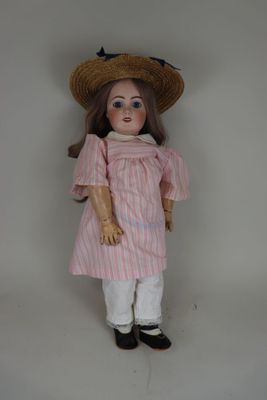 une image représentant une poupée portant un chapeau de paille et une robe rose