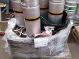 Plusieurs fûts de bière sont empilés sur une palette dans un entrepôt