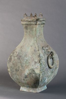 un vase posé sur un socle, sur une surface grise
