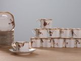 many cups and saucers sitting on a table