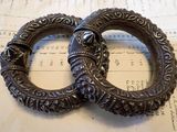 deux bracelets en argent posés sur une feuille de papier