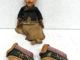 three pairs of shoes and a figurine of a man sitting on the ground