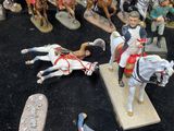 many figurines of soldiers on display on a black surface