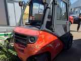 un chariot élévateur rouge garé sur un parking