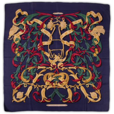 a close up of a blue scarf with gold and red designs
