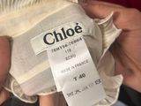 the label on a white dress is being held by a person