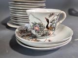 a cup and saucer sitting on a table next to a stack of plates