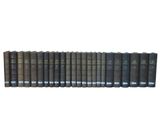 a row of books sitting on top of each other on a white surface