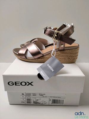 the box is open and has a pair of sandals on top of it