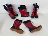 quatre paires de bottes rouges et noires sont alignées sur une surface blanche