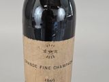 an old bottle of wine sitting on top of a table