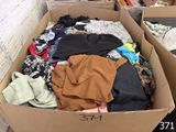 une boîte en carton remplie de vêtements dans une pièce