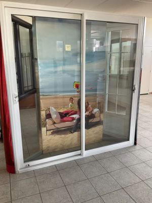 deux personnes allongées sur un canapé dans une pièce dotée de baies vitrées coulissantes