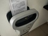 a paper dispenser in the corner of a bathroom