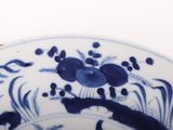 a blue and white plate with flowers and birds on it