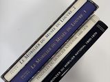 three books are stacked on top of each other on a table