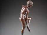an image of a bronze statue of a man holding a soccer ball