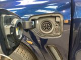 a close up of a blue car with a gas pump attached to it ' s side