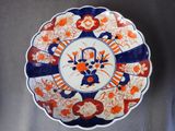 une assiette orange et bleue décorée de fleurs, posée sur une table