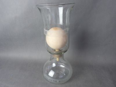 a glass vase with an egg in it on a table