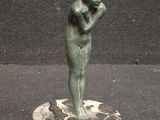 une statue représentant un homme tenant sa tête entre ses mains