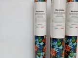 three rolls of paper with flowers on them on a table