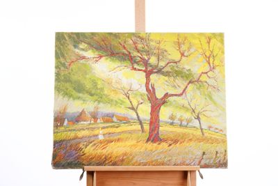 an oil painting of a tree on a easel in front of a white wall