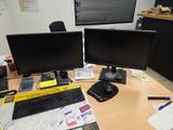 deux écrans d'ordinateur posés sur un bureau, à côté d'un clavier et d'une souris