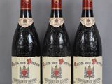 trois bouteilles de vin rouge posées sur une table en verre