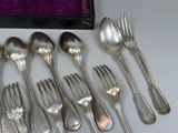 a lot of spoons and forks sitting on a table