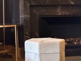 a white ottoman sitting in front of a fireplace in a living room