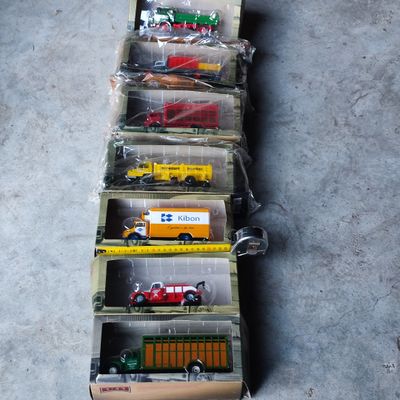 Plusieurs camions miniatures sont alignés en rang sur le sol