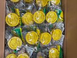 a cardboard box filled with lots of yellow and green lollipops