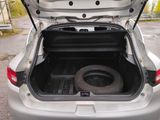 a tire in the trunk of a silver car