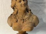 an image of a busturine of a woman on a wooden stand