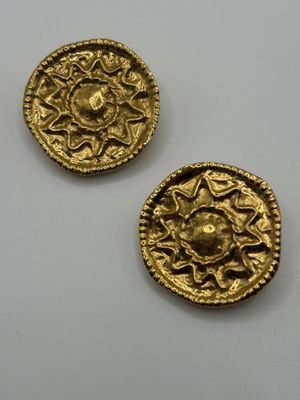 two gold coins, one of which is a sun and the other of which is a flower