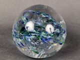 a glass ball with a bird in it on a table