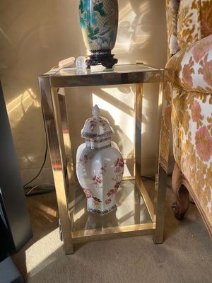 une table en verre sur laquelle se trouve un vase, à côté d'une chaise