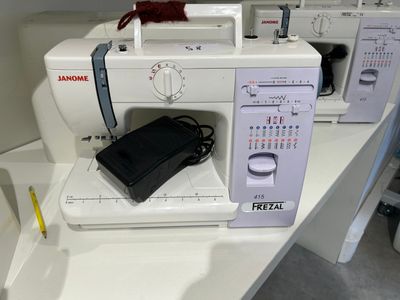 a sewing machine on a table with other sewing machines