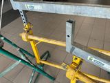 a yellow scaffolding on the floor next to a green scaffolding