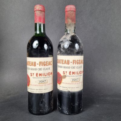two bottles of red wine sitting next to each other on a table