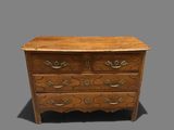 a wooden chest of drawers with ornate carvings and brass handles