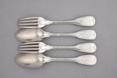 six cuillères et une fourchette en argent sur une surface grise