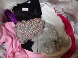a pile of clothes sitting on top of a bed