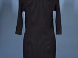 black knit dress on a mannequin stand against a blue background