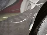 a close up of a car ' s side door with a cracked tire