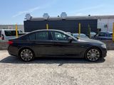 a black bmw sedan parked in front of a building