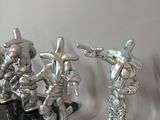 three silver figurines that are sitting on a table